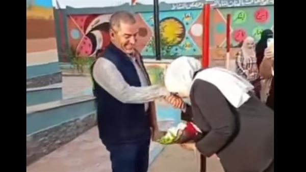 معلمة تقبل يد زوجها في الطابور
