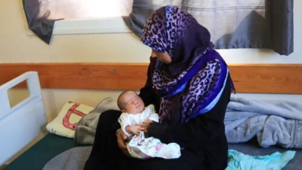 إمرأة فلسطينية وطفلها في إحدى مستشفيات قطاع غزة